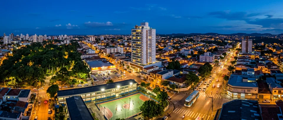Vista aérea do bairro com parque, mercado, escola e ônibus